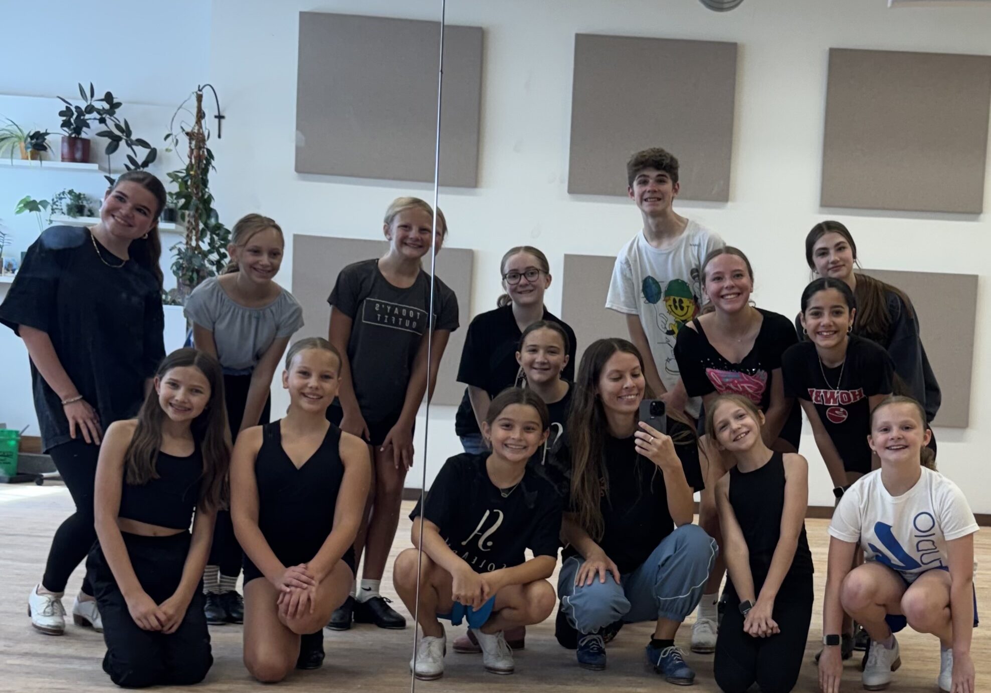 A group of intermediate youth tap dancers pose for a group picture with their teachers